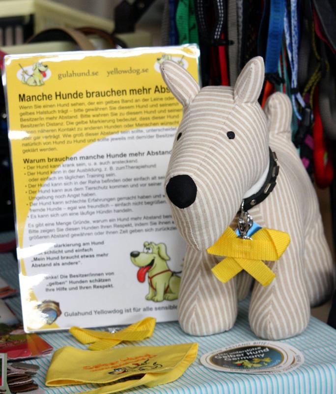 Stoffhund mit gelber Schleife und Informationsmaterial zum Projekt Gelber Hund